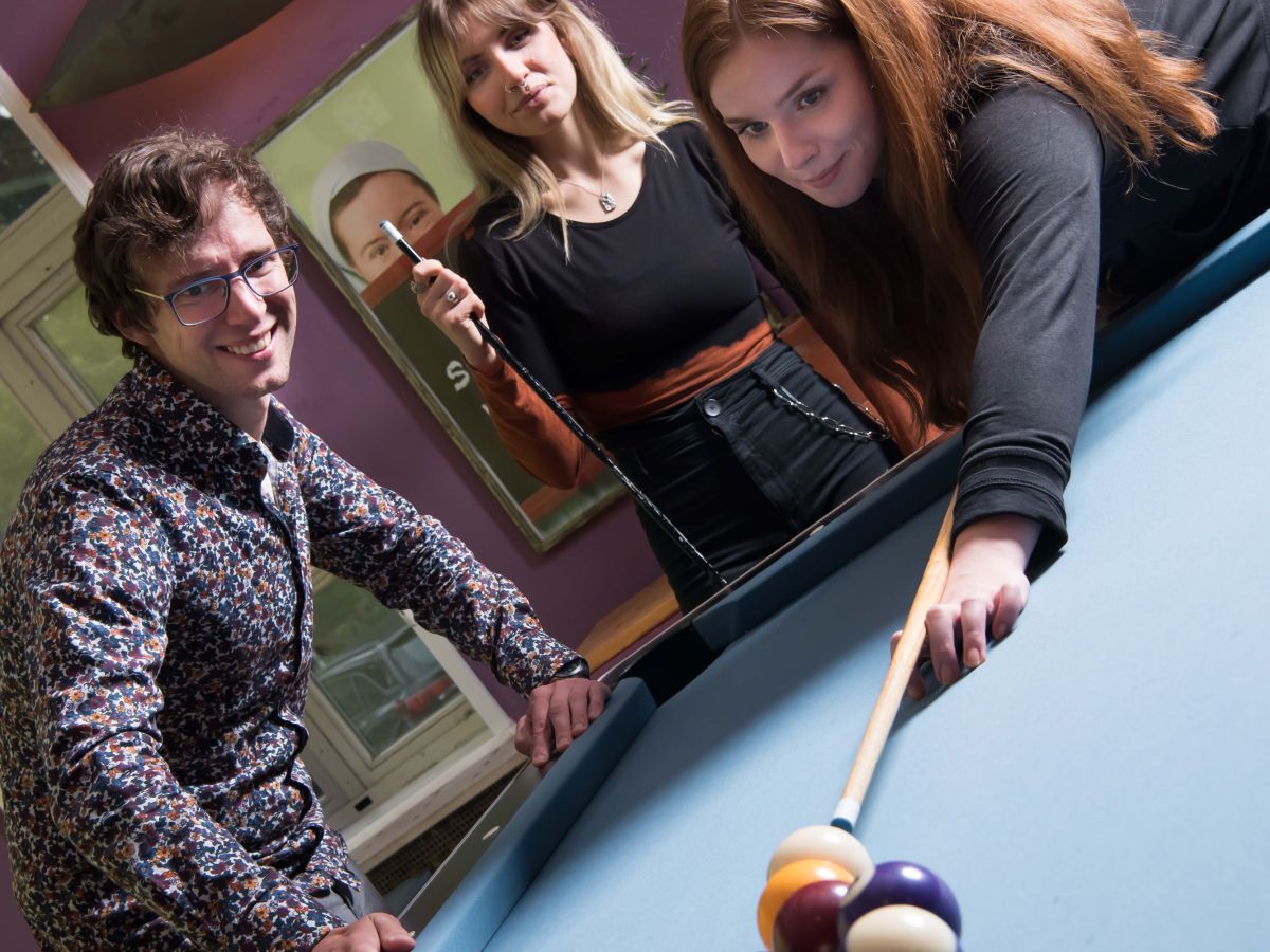 Drei Personen spielen Pool-Billard